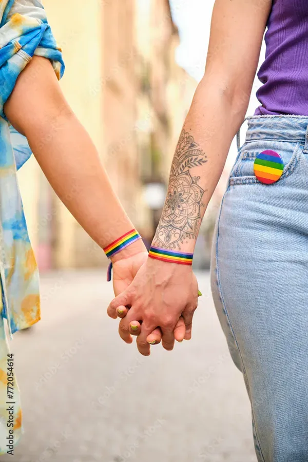 A lesbian couple holding hands with pride wristbands. Schedule LGBTQ+ primary care from The Cove Concierge Medicine in Denver.