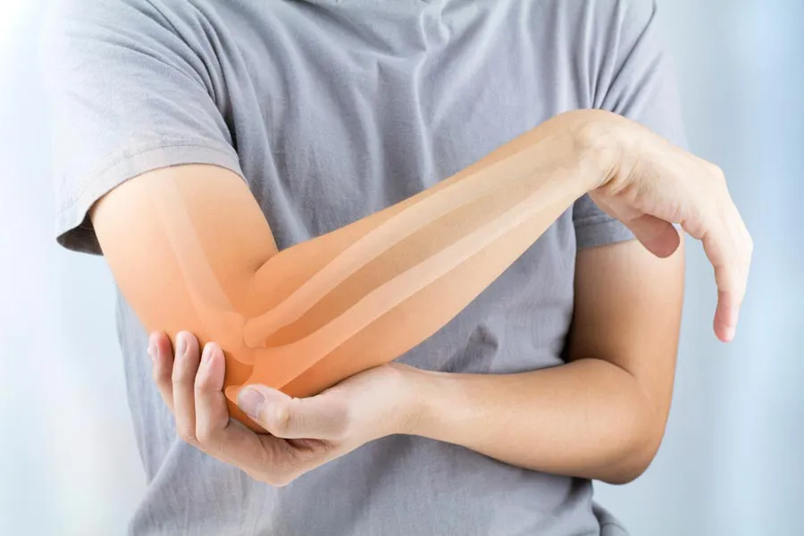 A close-up of a woman holding her elbow with an illustration of the bones and joint experiencing pain from osteoporosis. Get osteoporosis treatment from The Cove Concierge Medicine in Denver.