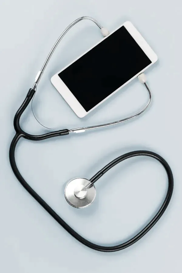 Close up of a stethoscope and a phone representing telemedicine services offered by The Cove Concierge Medicine in Denver.